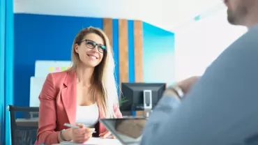 Smiling woman in glasses having a meeting in a bright office.